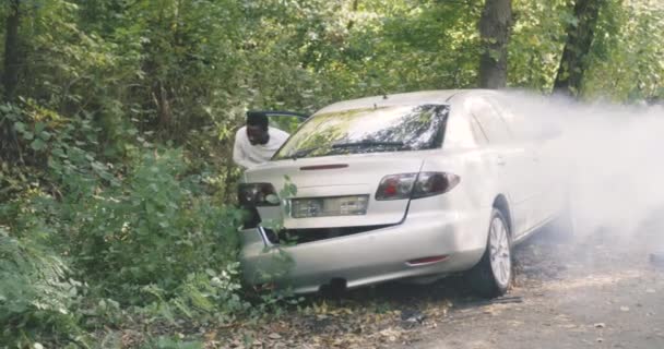 車がクラッシュした後に電話をかけるブラックサバイバー — ストック動画