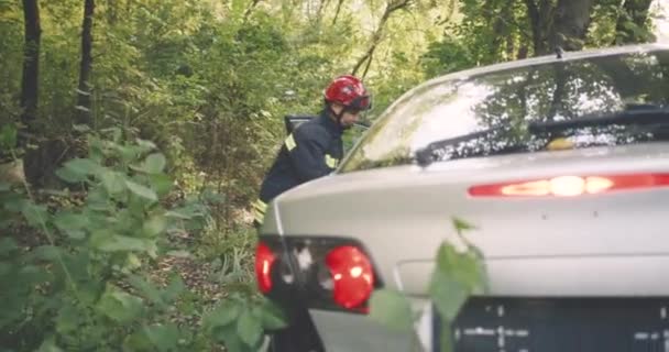 Bomberos salvando a la gente del coche destrozado — Vídeos de Stock
