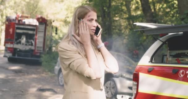 Mujer herida hablando en el teléfono inteligente después de accidente de coche — Vídeo de stock