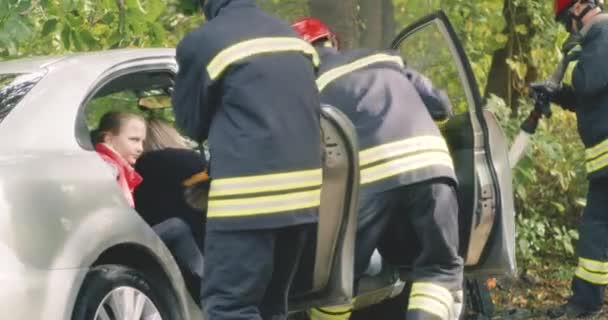 Firefighters saving people and extinguishing fire after car crash — Stock Video