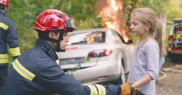 Пожежник допитує дівчину після автокатастрофи — стокове відео