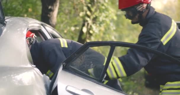 Brandweermannen redden zwarte man na auto-ongeluk — Stockvideo