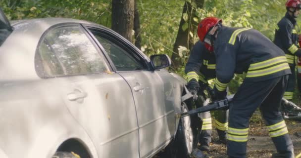 Firefighters removing wheel of broken car — Stock Video
