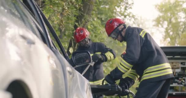 Brandweerlieden openen verbrijzelde deur van de auto — Stockvideo