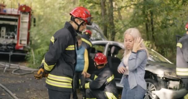 Fireman speaking with female victim of car crash — Stock Video