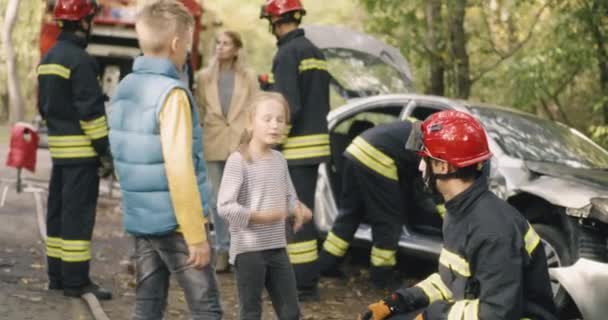 Brandweerlieden ondervragen familie na auto-ongeluk — Stockvideo