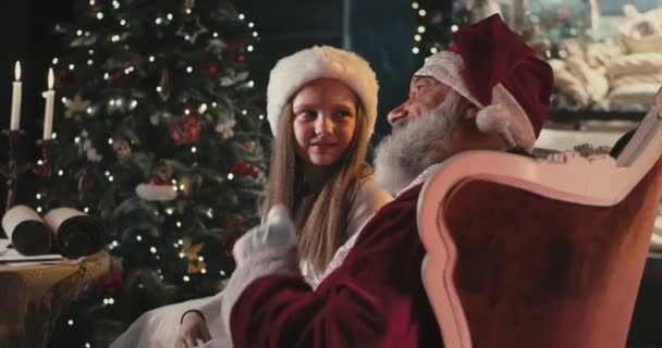 Санта Клаус разговаривает с девушкой в канун Рождества — стоковое видео