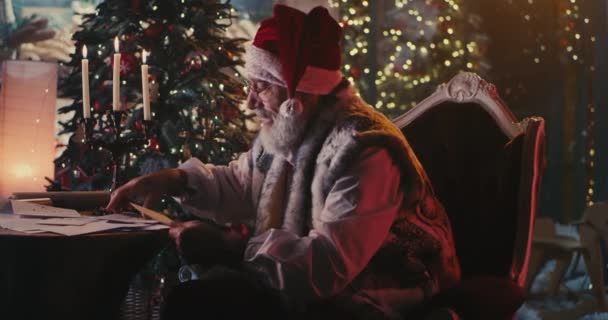 Santa Clause leyendo cartas y pergamino — Vídeos de Stock