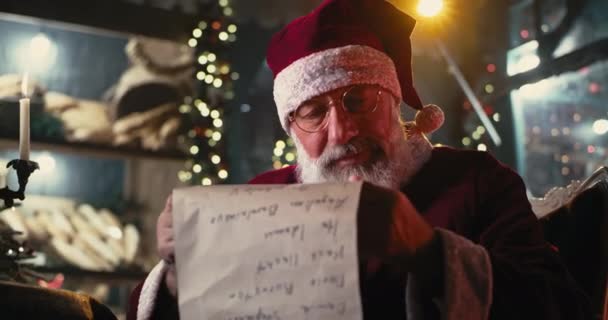 Kerstman lezen scroll op kerstavond — Stockvideo