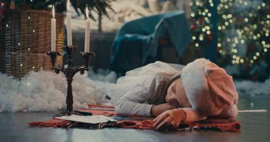 Noel ağacının yanında uyuyan kız