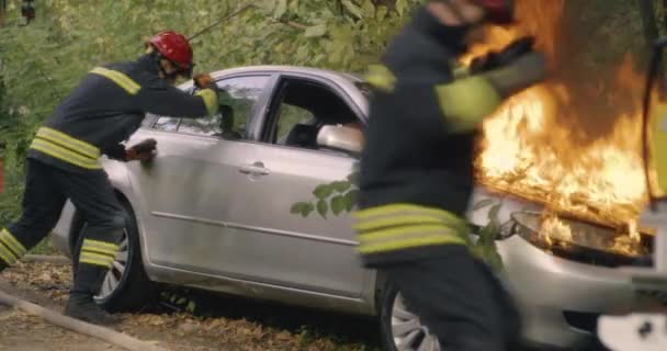 Hasiči zachraňují matku a děti z hořícího vozidla — Stock video
