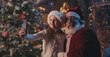 Mutlu kız Noel Baba 'yla selfie çekiyor.