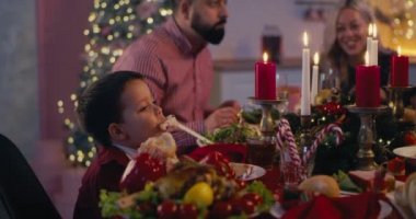 Noel 'de ailesiyle yemek yiyen çocuk.