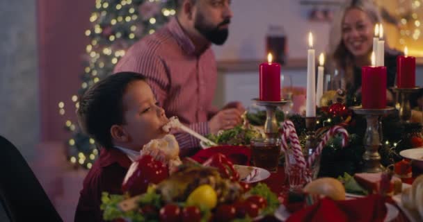 Хлопчик на різдвяній вечері з сім'єю — стокове відео