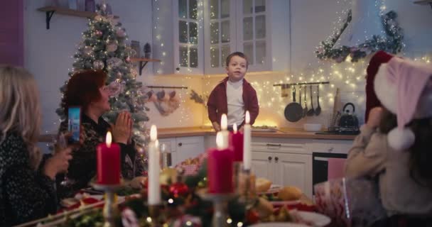Küçük çocuk Noel yemeğinde aile için şiir okuyor. — Stok video