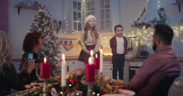 Schattige kinderen die gedichten opvoeren op kerstdiner met familie — Stockvideo