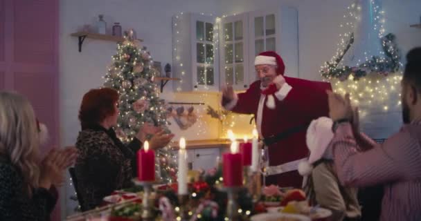 Gülen aile Noel Baba kostümlü dedeyi hediyelerle karşılıyor. — Stok video