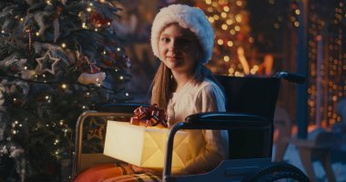 Şaşırmış engelli kız Noel Baba 'dan hediye alıyor.