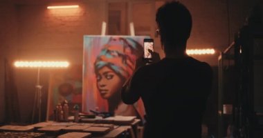 Anonim ressam sanat eserlerinin fotoğrafını çekiyor.