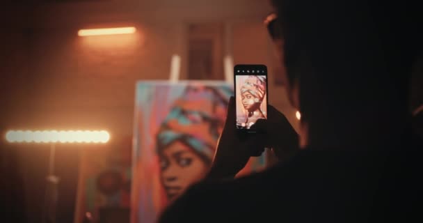 Неузнаваемый ремесленник фотографирует портрет за верстаком — стоковое видео