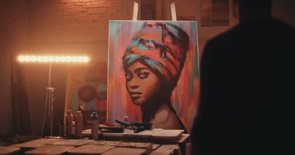 Анонимный художник думает над живописью в студии — стоковое видео