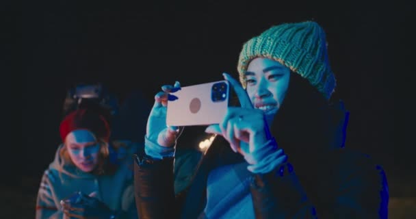 Mujer feliz grabando fuegos artificiales de vacaciones en la noche de invierno — Vídeos de Stock