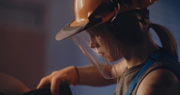 Gericht vrouwelijk arbeider in beschermende helm werken op zware apparatuur — Stockvideo