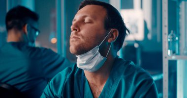 Laboratuvarda çalışırken esnemekten yorgun düşmüş doktor.