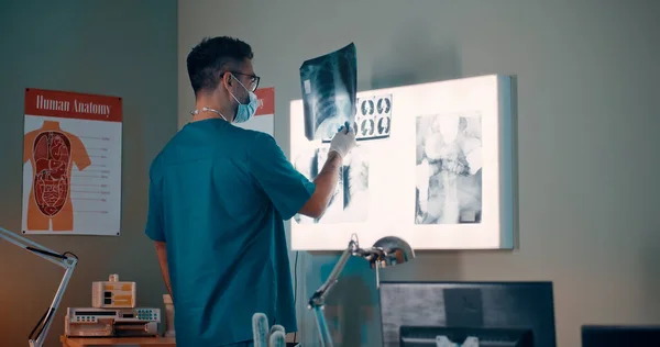 Доктор исследует легкие рентгеновского луча против лампы — стоковое фото