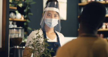 Coronavirus salgını sırasında kafede çok ırklı kasiyer ve müşteri