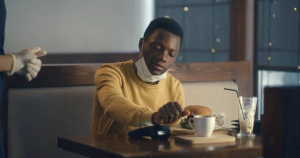 未来のチップ技術で食事代を支払うカフェテリアの黒人男性 — ストック写真