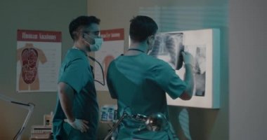 Erkek doktorlar akciğerlerini inceliyor. Coronavirüs hastasının röntgeni.