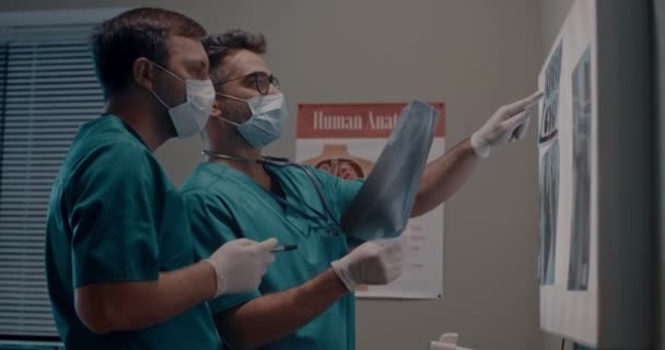 Doctors in masks discussing lungs X rays — Stock Video