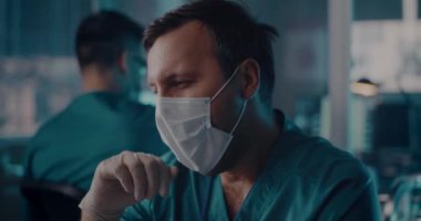 Laboratuvarda çalışırken esnemekten yorgun düşmüş doktor.