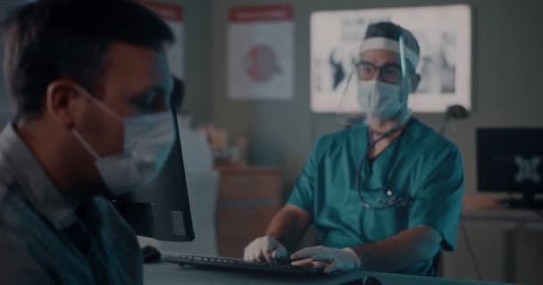 Пациент в маске разговаривает с доктором — стоковое видео