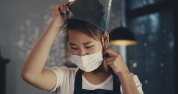Joven asiático barista deshacerse de la protección de la cara y sonriendo — Vídeos de Stock