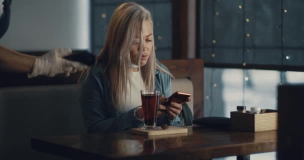 Молодая женщина платит бесконтактной картой за заказ кафе — стоковое видео