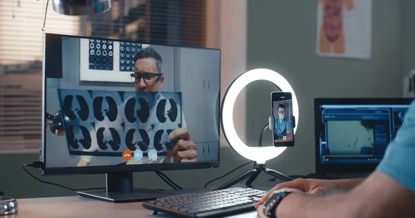 Volwassen arts toont röntgenfoto aan collega gewas tijdens online seminar — Stockfoto
