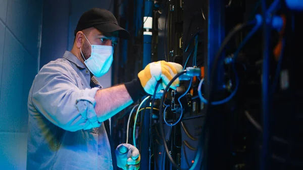 Technician in mask fixing LED screen