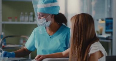 Klinikte etnik tıp pratisyeni aşılayan kız.