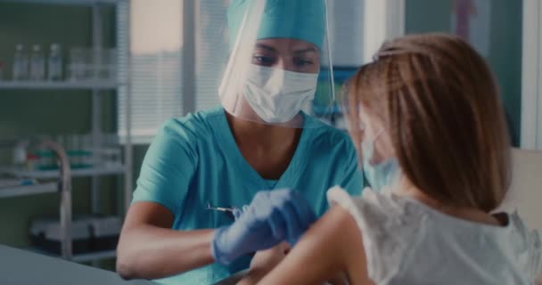 Médico femenino negro vacunando a una niña durante la epidemia — Vídeos de Stock
