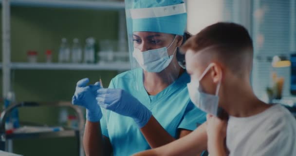 Médico negro vacunando a un niño en el hospital — Vídeos de Stock