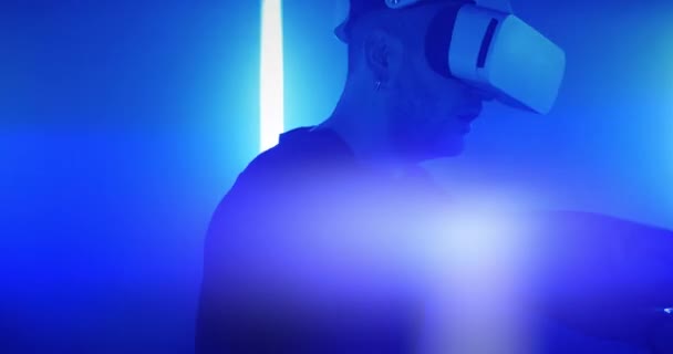 Людина досліджує віртуальну реальність під синім освітленням — стокове відео