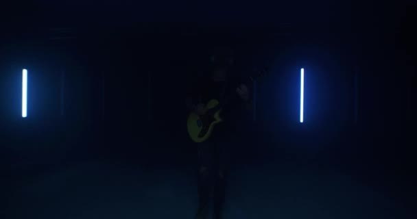 Впевнений гітарист виступає проти яскравих ламп — стокове відео