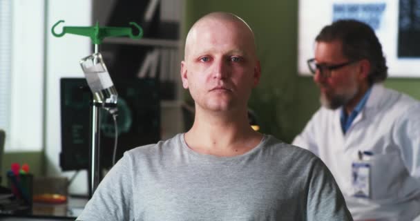 在肿瘤学家旁边看着摄像机的秃头男人很不高兴 — 图库视频影像