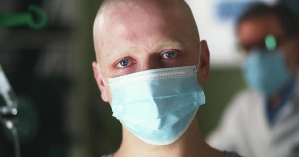 Hombre calvo con máscara mirando a la cámara en el hospital — Vídeos de Stock