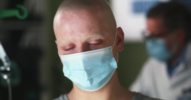 Paciente con cáncer infeliz en máscara durante la cita en la clínica — Vídeos de Stock