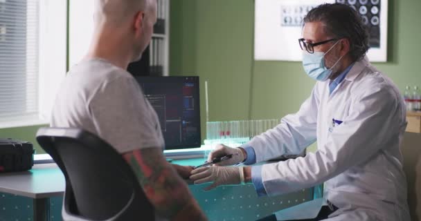 Doctor inyectando chip RFID en la mano del paciente en el laboratorio — Vídeos de Stock