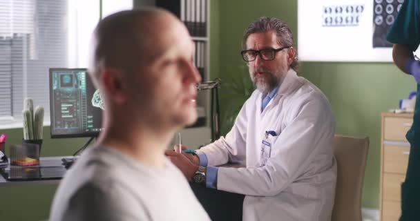 Homme chauve parlant avec un oncologue pendant la vaccination — Video