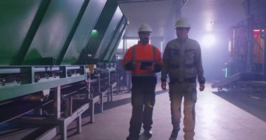 Erkek müfettişler taşıma bandını kontrol ediyor